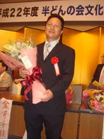 祝福の花束を手にする岡田部長